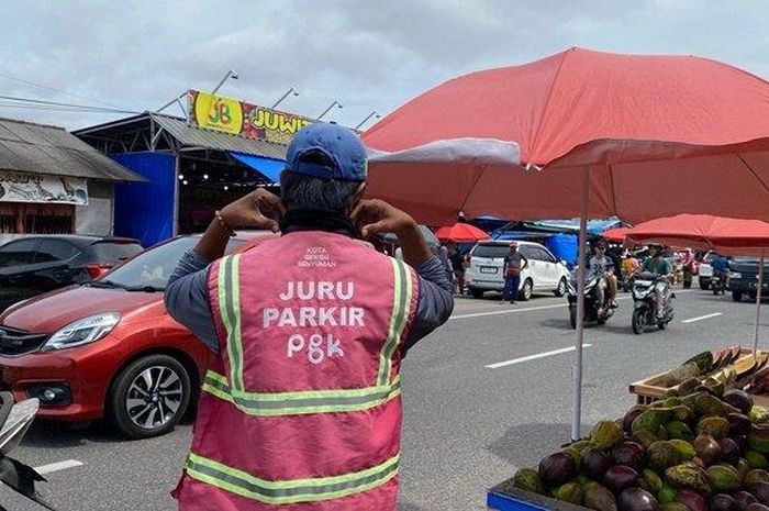 Ilustrasi Juru Parkir (Jukir) resmi Kota Pangkalpinang yang mengenakan rompi pink sebagai tanda juru parkir resmi, di jalanan Kota Pangkalpinang, Jumat (14/3/2025)   