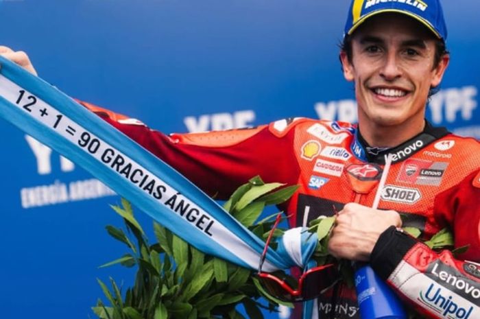 Marc Marquz rayakan kemenangan dengan bendera bertuliskan 12 + 1 = 90 Gracias Angel. Ternyata maknanya dalam ditujukan untuk legenda balap Angel Nieto.