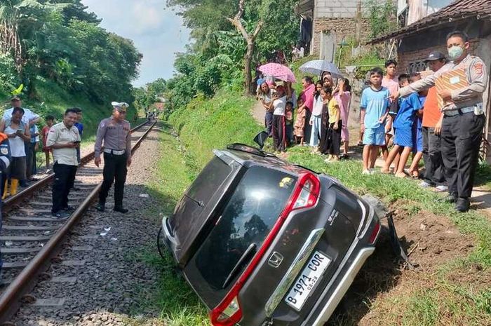 Honda BR-V tersungkur di selokan tepi rel setelah tertemper kereta api lokal Merak di perlintasan Kelurahan Cijoro Lebak, Rangkasbitung, Kabupaten Lebak, Banten