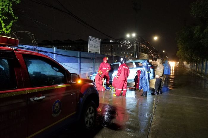 uku Dinas Penanggulangan Kebakaran dan Penyelamatan (Gulkarmat) Jakarta Utara evakuasi Toyota Transmover Blue Bird terperosok selokan