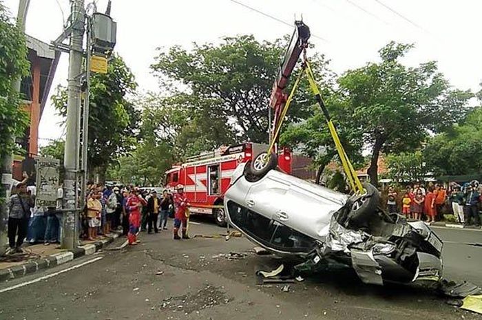 Evakuasi Toyota Avanza yang kayang tatap langit atau terbalik di Jl Kusuma Bangsa, kota Surabaya, Jawa Timur