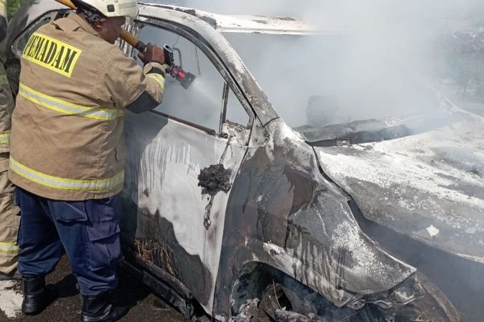 Petugas pemadam kebakaran berusaha memadamkan api yang membakar Toyota Kijang Innova Zenix di exit tol PIK, Jakarta Utara