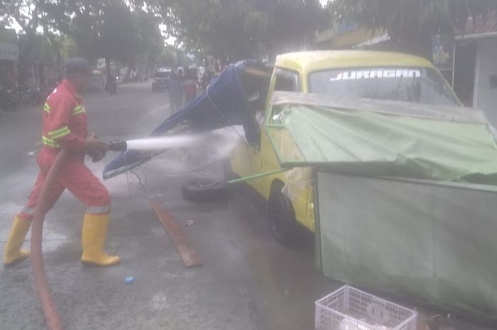 Petugas Pemadam dan Penyelamatan Satpol PP Cilacap semprotkan api ke Suzuki Carry pikap milik pedagang tahu bulat yang terbakar akibat minyak jelantah tumpah ditabrak Honda Brio di Jl Diponegoro, Majenang, kabupaten Cilacap, Jawa Tengah