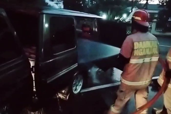 Petugas pemadam kebakaran Nganjuk semprotkan air ke dalam kabin Toyota Kijang Grand Extra di ByPass Nganjuk