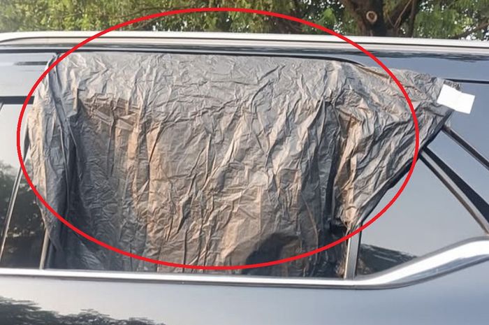 Dalam lingkaran merah, jendela pintu kiri belakang Toyota Fortuner terpaksa ditutup kresek hitam setelah dipecah maling di tepi Jl Ir Juanda, Sukmajaya, kota Depok, Jawa Barat