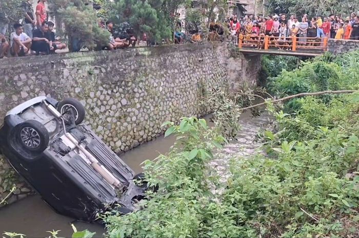 Suzuki Grand Vitara anggota DPRD Tulungagung, Subani Sirab terpental posisi kayang ke sungai sedalam 4 meter di desa Gandong, Bandung, Tulungagung, Jawa Timur 