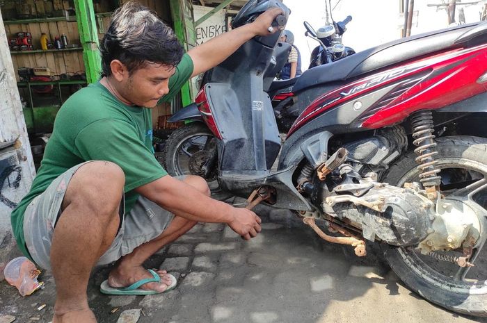 Yoga menunjukan kondisi Honda Vario 110 yang penuh karat akibat sering menerjang banjir rob Sayung Demak, Jawa Tengah