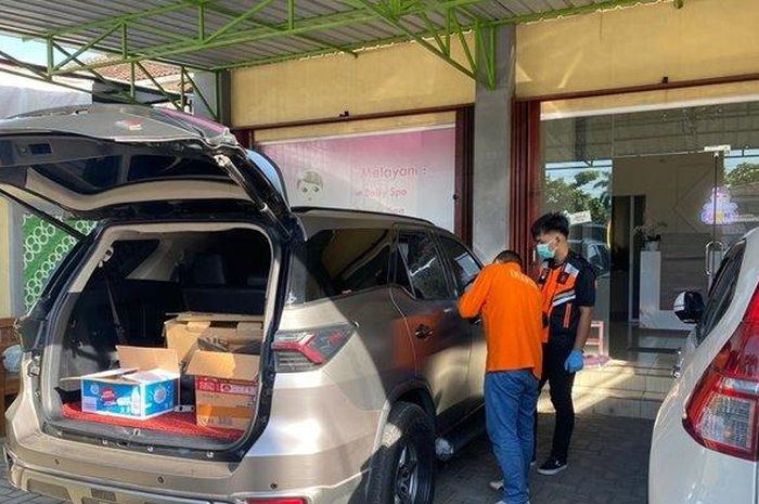 Tim INAFIS Polri memeriksa kaca pintu tengah sisi kanan Toyota Fortuner yang dipecah pelaku pencurian di parkiran ruko padukuhan Kedunggong, Wates, Kulon Progo, Yogyakarta 
