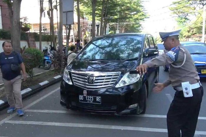 Polisi menggiring Toyota Alphard nopol DD 1223 RE saat Operasi Patuh di kota Makassar, pengemudi ditilang karena menunggak pajak Rp 40 juta