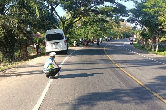Dua Polisi olah TKP kecelakaan tunggal Toyota HiAce yang terbalik menewaskan satu penumpang dan melukai 12 orang di jalan raya Medan-Banda Aceh, Desa Sineubok Pidie, Peureulak, Aceh Timur, Aceh, (18/7/25)