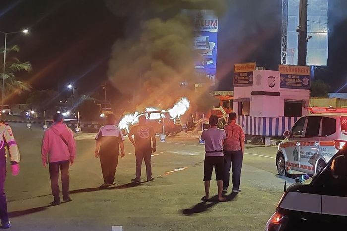 Warga dan petugas tonton sebuah Mitsubishi Outlander terbakar di bundaran Alohan, Sidoarjo, Jawa Timur