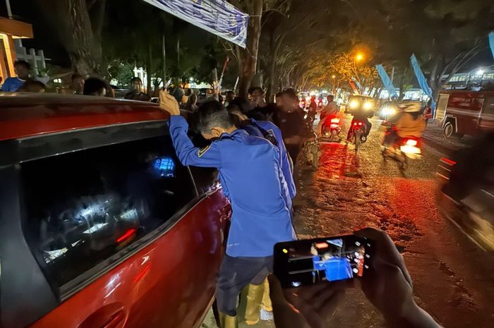 Tim Damkar kabupaten Lamongan berusaha membujuk balita yang terkunci di dalam kabin Toyota Rush untuk membuka kunci