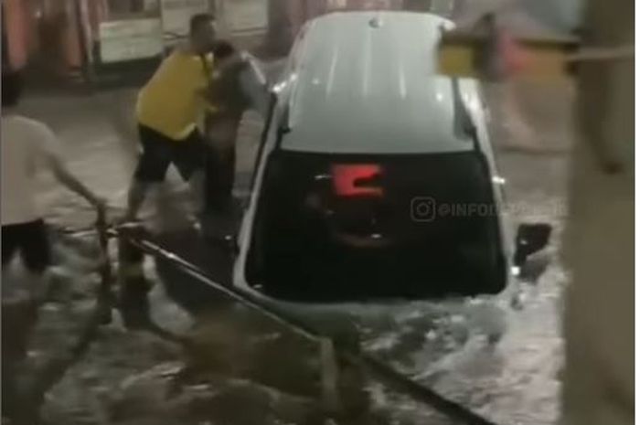 Proses penyelamatan dua anak dan ayah dari dalam Mitsubishi Xpander Cross yang terjungkal ke selokan akibat banjir di Bukit Cengkeh 2, Cimanggis, Kota Depok, (11/8/25) malam.