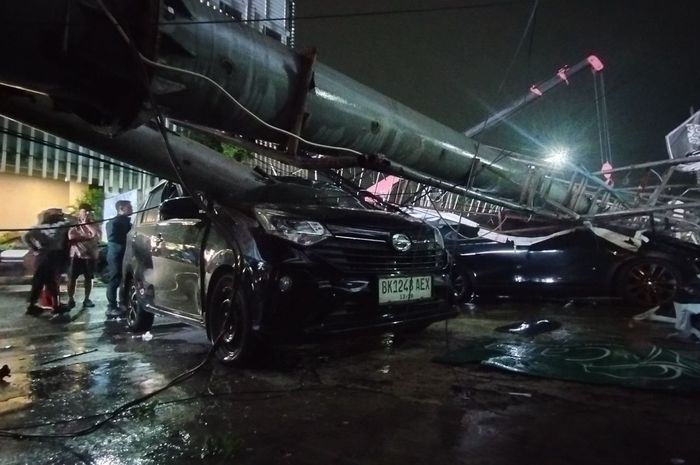 Tiang dan papan reklame setinggi 10 meter roboh menimpa tiga mobil dan delapan motor di Jl Zainul Arifin, kota Medan, Sumatera Utara