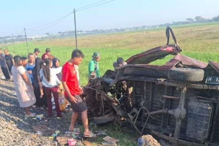 Suzuki Carry tergeletak tak berdaya dengan kondisi bodi ringsek parah usai dihajar kereta api