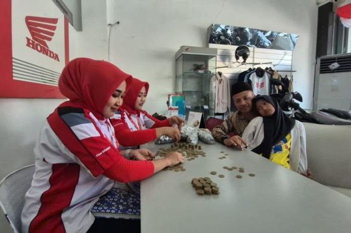 Sunarta (51) bersama anaknya bawa empat karung dan satu kardus uang koin ke dealer motor Honda di Jl Urip Sumoharjo, Mangkujayan, Ponorogo untuk beli motor matic