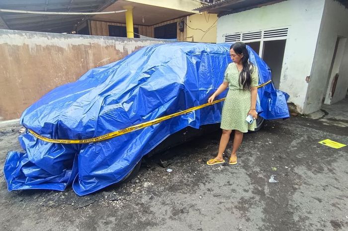 Nur Rohmatus, warga Dusun Kebonsari, Desa Jarit, Candipuro, Kabupaten Lumajang, Jawa Timur tunjukan Nissan Juke miliknya yang dibungkus terpal biru karena diduga dibakar orang tak dikenal