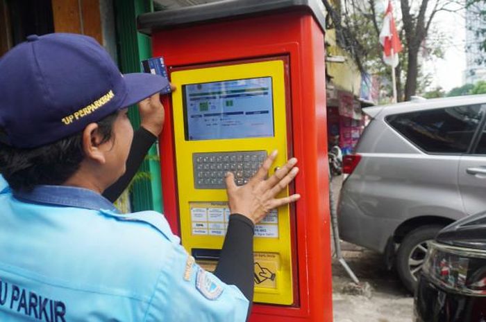 Juru parkir mengoperasikan mesin parkir di Jalan Sabang, Menteng, Jakarta Pusat
