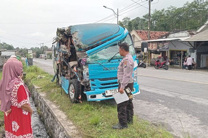 Isuzu Elf yang ditumpangi rombongan SMK Negeri Tempursari terkoyak separuh bodi kanan hingga bolong di jalan raya Lumajang-Malang, desa Sumberwuluh, Candipuro, kabupaten Lumajang, Jawa Timur