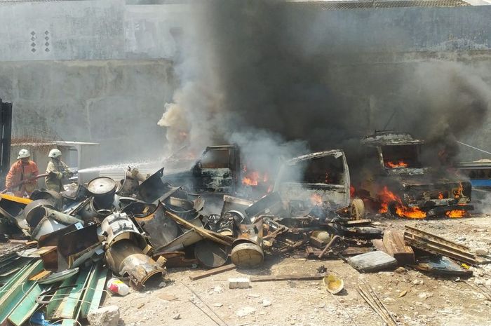 Tim pemadam kebakaran berusaha memadamkan api yang membakar empat mobil bangkai di gudang rongsokan Jl Wonosari Lor, Wonokusumo, Semampir, Surabaya, Jawa Timur