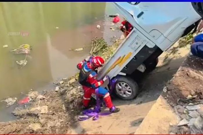 Tim Gulkarmat Jakarta Timur memasang tali untuk mengevakuasi Daihatsu Gran Max pikap yang tercebur Kali Sunter, Pulogadung, Jakarta Timur