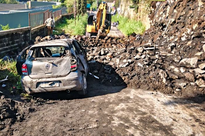 Nissan March babak belur dihajar material longsor, satu keluarga di kabin sempat terjebak di dalam.