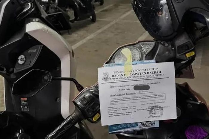 Motor yang terparkir di Stasiun Pondok Ranji, Ciputat, Tangerang Selatan ditempeli secarik kertas berisikan imbauan agar pemilik melunasi pajak kendaraan yang sudah menunggak, pemasangan dilakukan petugas Samsat