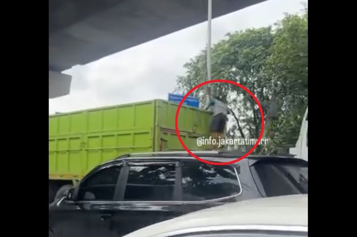 Dalam lingkaran merah aksi bajing loncat mencuri muatan besi dari truk tronton yang terjebak macet di jalan Raya Bekasi, Cakung, Jakarta Timur.
