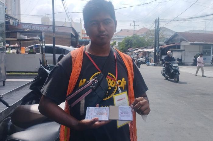 Salah satu tukang parkir di kota Medan, Sumatera Utara yang menunjukan karcis parkir terbaru dengan tarif Rp 4.000 untuk mobil dan Rp 2.000 untuk motor
