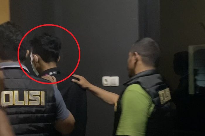 Dalam lingkaran merah, TL (34) pelaku penipuan jual beli Yamaha NMAX bekas sekaligus mengaku-ngaku karyawan TV Swasta nasional digiring Polisi