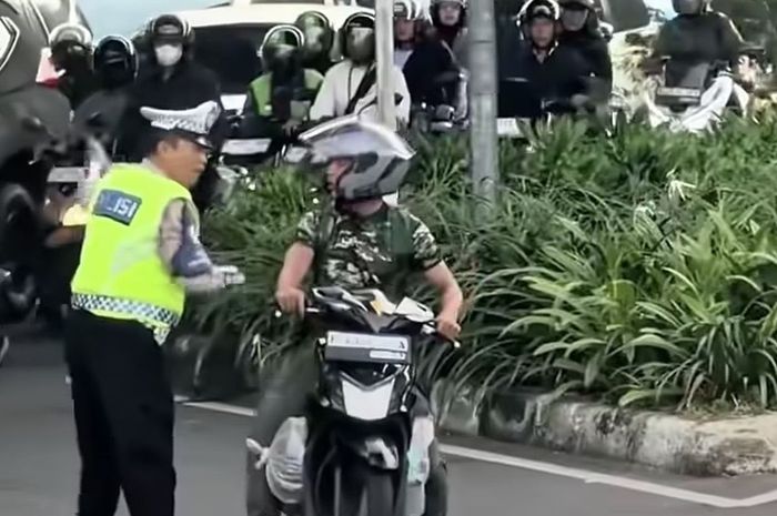 Polisi dan pengendara motor baju loreng cekcok di Jalan Mayjen Sutoyo, perempatan bawah flyover Cawang, Jakarta Timur, (7/4/26)