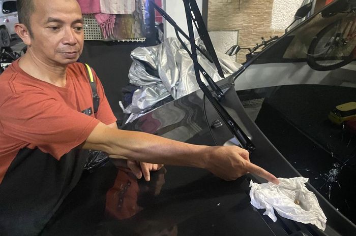 M Said (51) warga Sumber Rejo, Balikpapan Tengah, Balikpapan, Kalimantan Timur tunjukan proyektil peluru yang bersarang di kaca depan mobil Daihatsu Sigra miliknya saat parkir di garasi