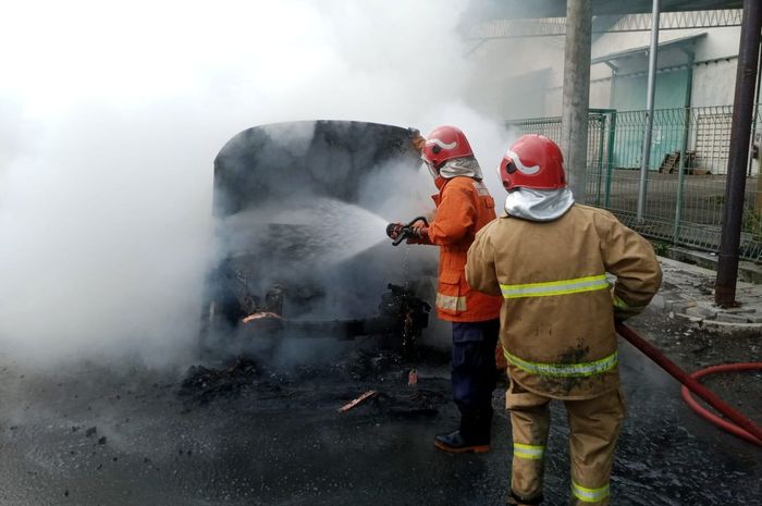 Petugas pemadam kebakaran menyemprot mobil listrik Hyundai Kona Electric yang terbakar di Jalan Mayjen Sungkono Blok B/4, Desa Gulomantung, Kecamatan Kebomas, Gresik, Jawa Timur