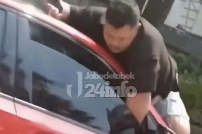 Viral video seorang pria bergelantungan di mobil