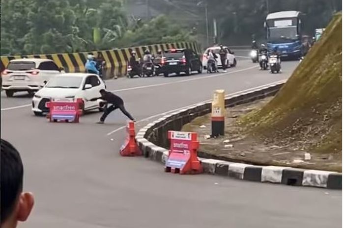 Toyota Agya diadang menggunakan water barrier dan ditimpuk helm oleh pengendara motor di kawasan Puncak Pass, Cianjur, Jawa Barat setelah dikejar-kejar debt collector