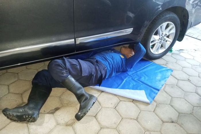 Anggota Damkar Pamekasan mencoba mengevakuasi ular Sanca sepanjang 3 meter yang terjepit di sela tangki BBM Toyota Kijang Innova Reborn saat idul adha, (27/5/26)