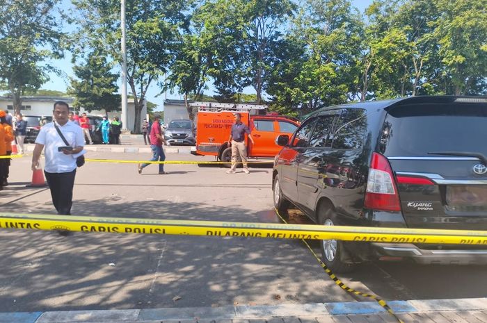 Toyota Kijang Innova pelat merah M 1090 GP milik Pemkab Bangkalan  yang terparkir di Bandara Juanda, Sidoarjo, Jawa Timur digaris Polisi karena ditemukan jasad ASN wanita di dalam kabinnya, (24/6/26)