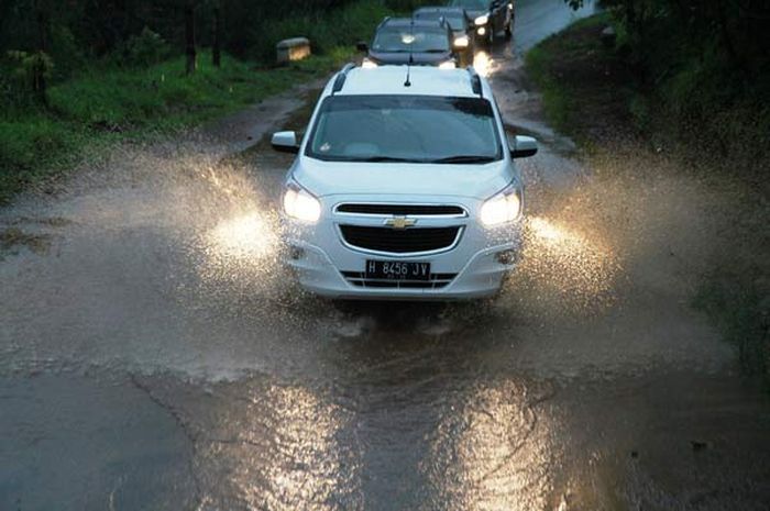 Ilustrasi mobil melintasi genangan air