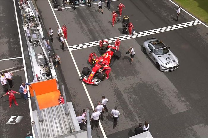 Mobil Kimi Raikkonen didorong keluar dari lintasan, padahal akan memulai lomba dari grid kedua di sirkuit Sepang, Malaysia