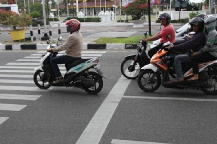 Ilustrasi pengendara motor terobos lampu merah.