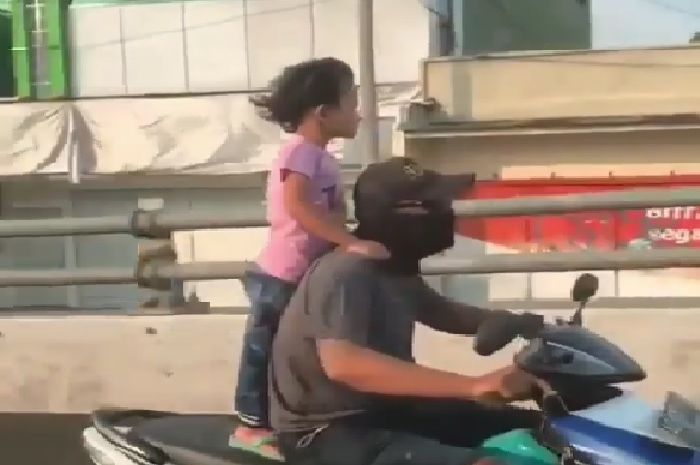 Orang tua yang membiarkan anaknya berdiri di atas motor