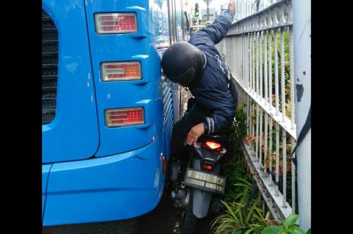 Pengendar motor terjepit Transjakarta