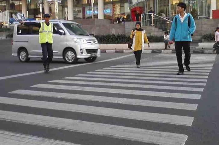 Pejalan kaki menggunakan zebra cross untuk menyeberang