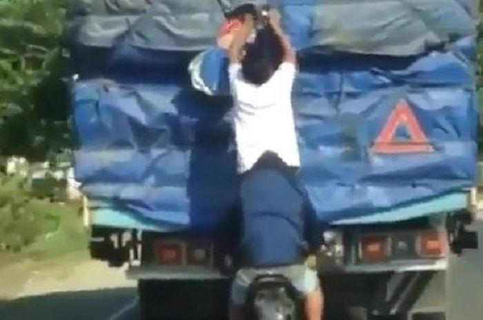 Bajing loncat membongkar barang bawaan sebuah truk.