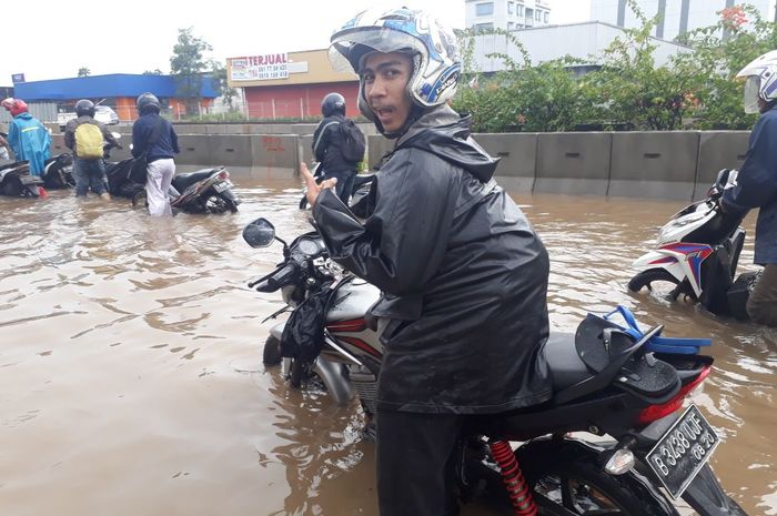 Pengendara motor yang terjebak banjir di Jakarta Utara