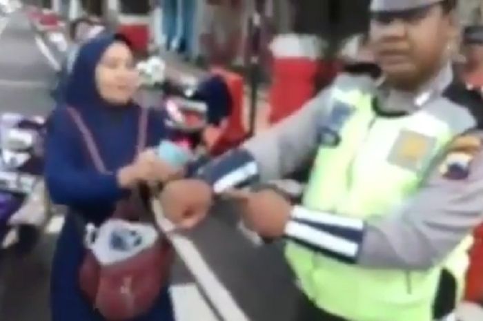 Polisi menunjukan luka ditangannya usai digigit emak-emak nekat.