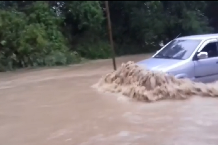 Isuzu Panther terlihat melewati genangan air banjir