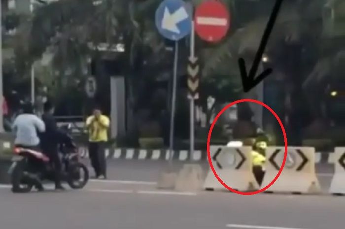 Polisi sembunyi dibalik pembatas jalan, seperti siluman.
