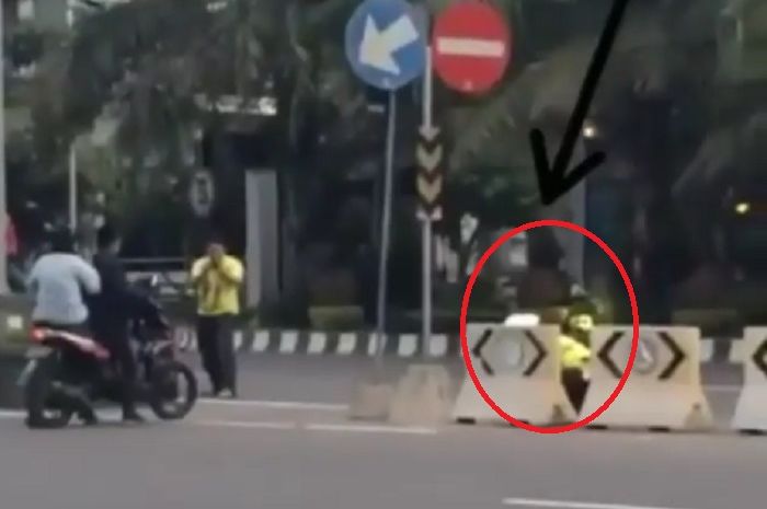 Polisi sembunyi dibalik pembatas jalan, seperti siluman.