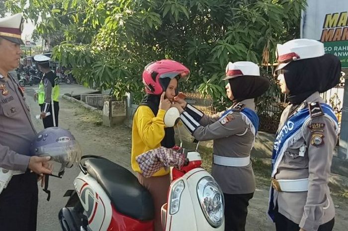 Polantas memberikan helm SNI bagi pengendara sepedamotor